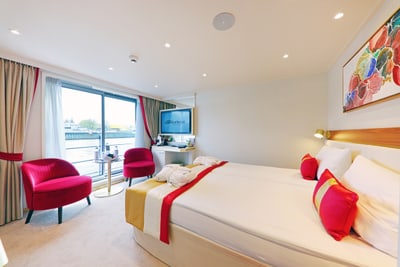 Helles Hotelzimmer mit grossem Bett und Balkon.