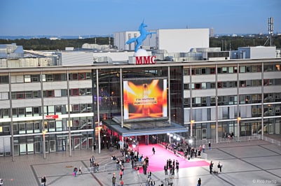 Menschen auf rotem Teppich vor dem MMC-Gebäude.