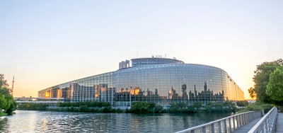 Moderne Glasgebäude am Fluss bei Sonnenuntergang.