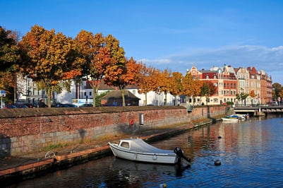 Herbstbäume und Boote an einem malerischen Kanal.