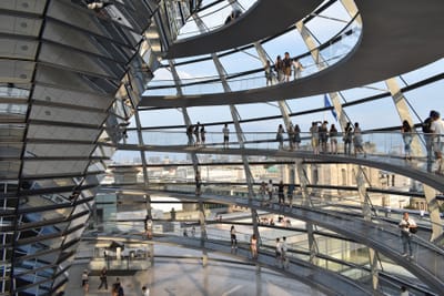Innenansicht der Glaskuppel mit Besuchern auf spiralförmigen Wegen.