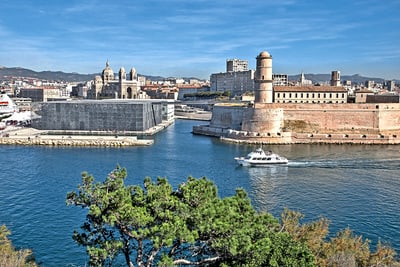 Blick auf Hafen von Marseille mit Kirche und historischen Gebäuden.