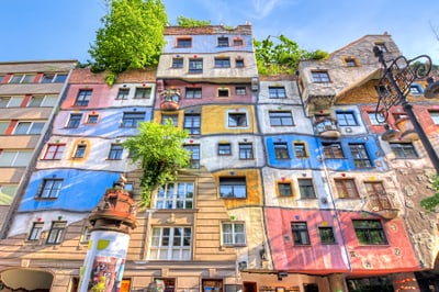 Bunt bemaltes Gebäude mit Bäumen auf dem Dach, klare Himmel.