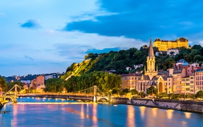 Abendansicht von Lyon mit Fluss, Brücke und Kirche.