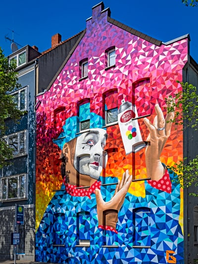 Buntes Wandbild eines Clowns mit Sprühdose.