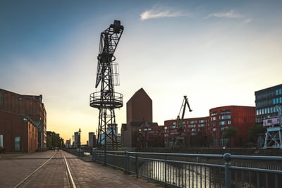 Industriekran und Gebäude an der Hafenkante bei Sonnenuntergang.