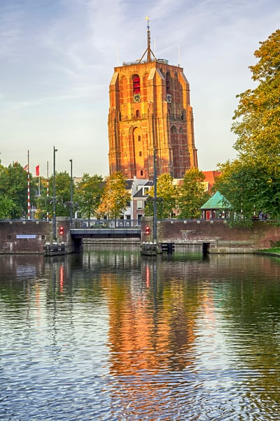 Alter Kirchturm in Leeuwarden, reflektiert im Wasser.