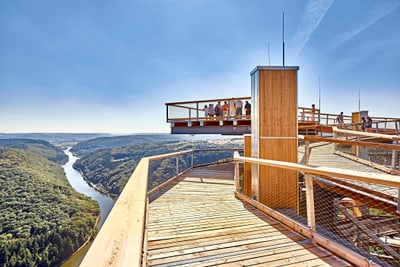 Aussichtsplattform über Flusstal in bewaldeter Landschaft.