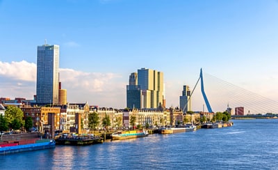 Stadtansicht von Rotterdam mit Brücke und modernen Gebäuden.