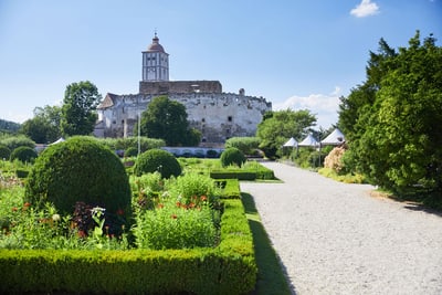 Garten mit Blick auf altes Schloss und umliegende Grünflächen.