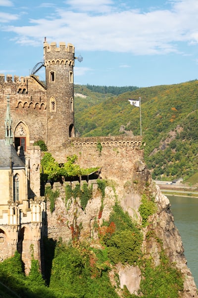 Mittelalterliche Burg auf Klippe über Flusslandschaft.