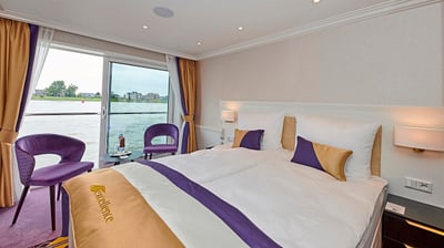 twerenbold_63383.jpg Elegantes Hotelzimmer mit grossem Bett und Flussblick.