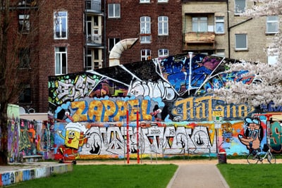 Wand mit buntem Graffiti in urbaner Umgebung.