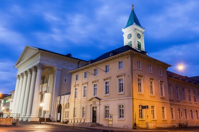 Historisches Gebäude mit Uhrturm bei Abenddämmerung.