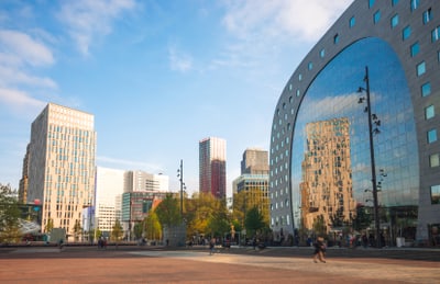 Platz mit modernen Gebäuden und Glasfassaden im Hintergrund.