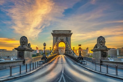 Historische Brücke bei Sonnenuntergang mit Löwenstatuen.