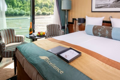 Luxuskabine mit Blick auf den Fluss, Tisch mit Sekt und Obst.
