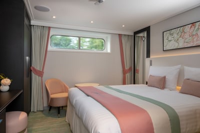 Elegantes Hotelzimmer mit Doppelbett und grossem Fenster.