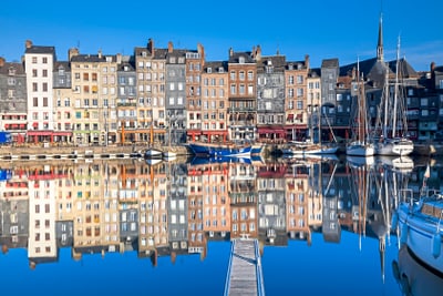 Hafen mit bunten Gebäuden und Segelbooten am Wasser in Honfleur.