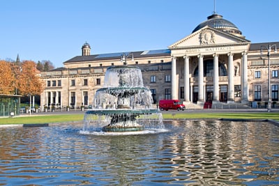 Brunnen vor dem historischen Gebäude mit Kuppel und Säulen.