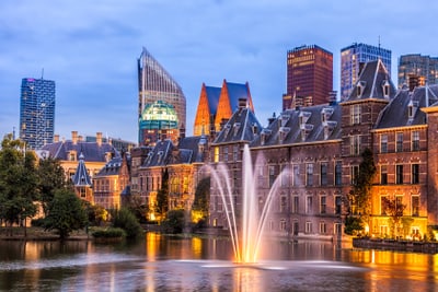 Abendansicht von Gebäuden und Springbrunnen in Den Haag.