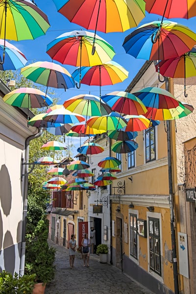Gasse mit bunten Regenschirmen überkopf hängend.