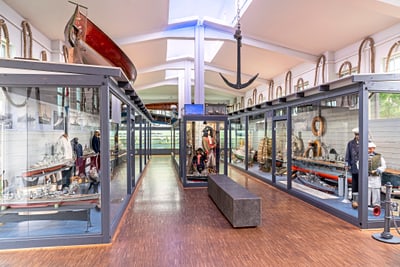 Schifffahrtsmuseum mit Booten und maritimen Exponaten in Vitrinen.