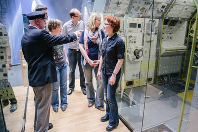 Gruppe von Menschen besichtigt technische Ausstellung.