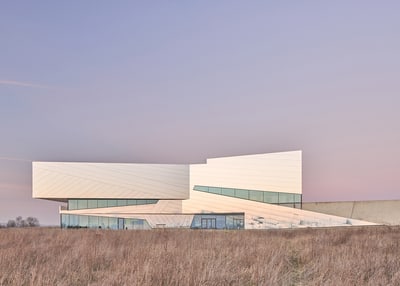 Moderne Architektur in ländlicher Landschaft bei Sonnenuntergang.