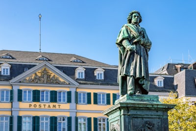 Statue vor historischem Gebäude mit gelben und weissen Fassaden.