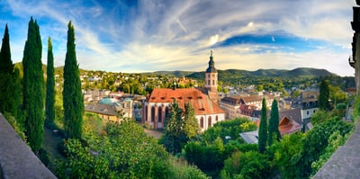 Panoramablick auf eine Stadt mit Kirche und umgebender Natur.