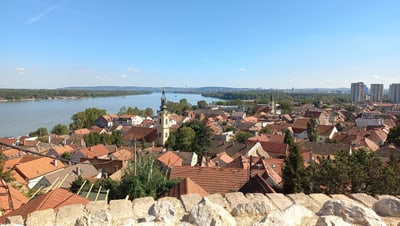 Panoramaansicht einer Stadt mit Fluss und roten Dächern.