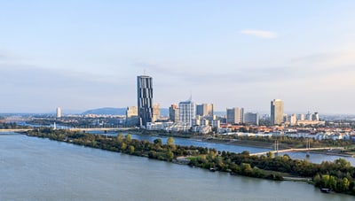Stadtansicht von Wien mit Donauturm am Flussufer.