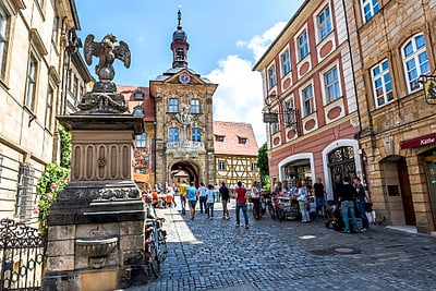 Altstadtstrasse mit Fachwerkgebäude und Menschen.