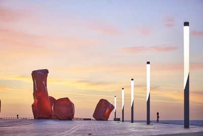 Skulpturen und leuchtende Masten bei Sonnenuntergang.