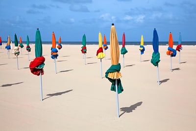 Bunte geschlossene Sonnenschirme am Strand.