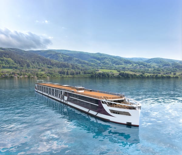 Flusskreuzfahrtschiff auf einem ruhigen Fluss vor bewaldeten Hügeln.